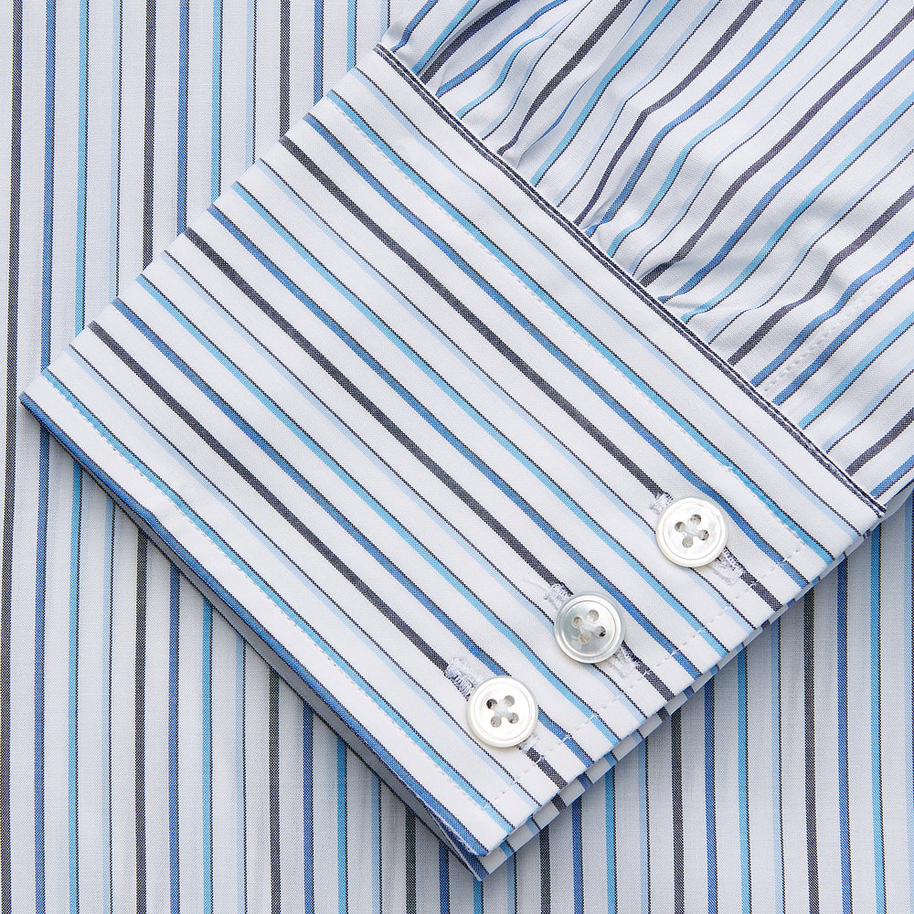 The Turnbull & Asser Blue Multi Blazer Stripe Regular Fit Mayfair Shirt features light blue and white vertical stripes, a signature Mayfair collar, and is neatly displayed on a white background.