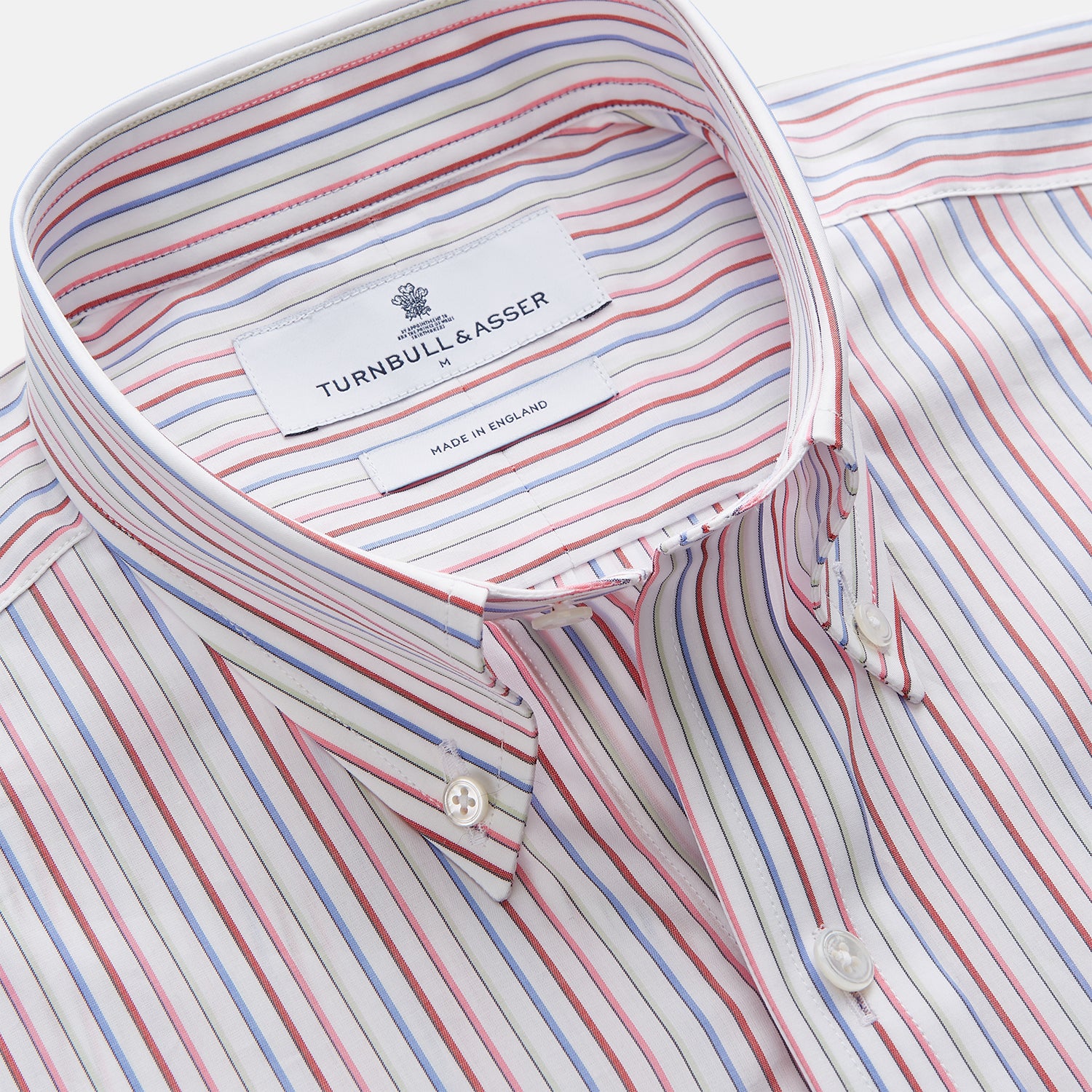 View 2 of product The Turnbull & Asser Red Multi Blazer Stripe Weekend Fit Suffolk Shirt features blue, red, and white stripes, a Dorset collar, single breast pocket, and long sleeves. Displayed flat against a white background.