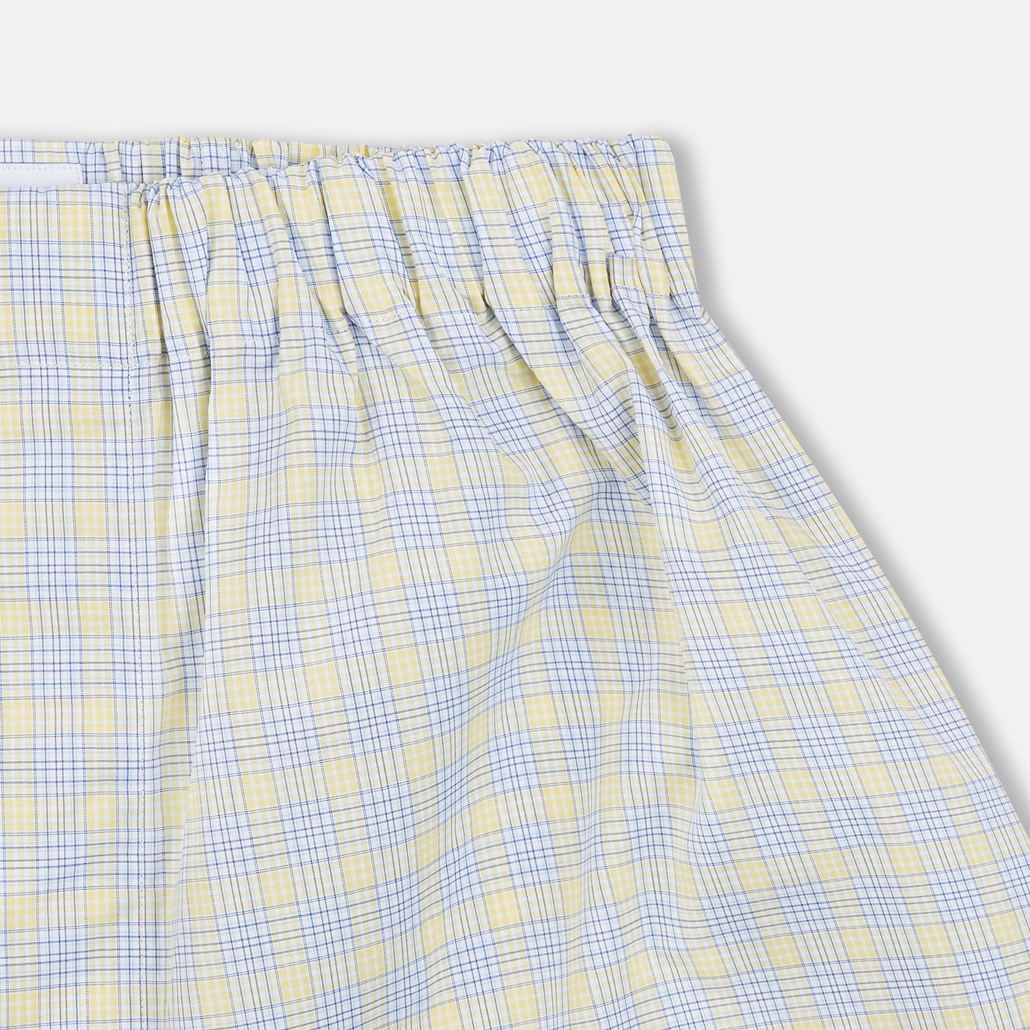 View 2 of product The Turnbull & Asser Yellow Multi Check Cotton Godfrey Boxer Shorts feature a light blue and yellow plaid, soft cotton fabric, and an elastic waistband, shown flat on a white background.