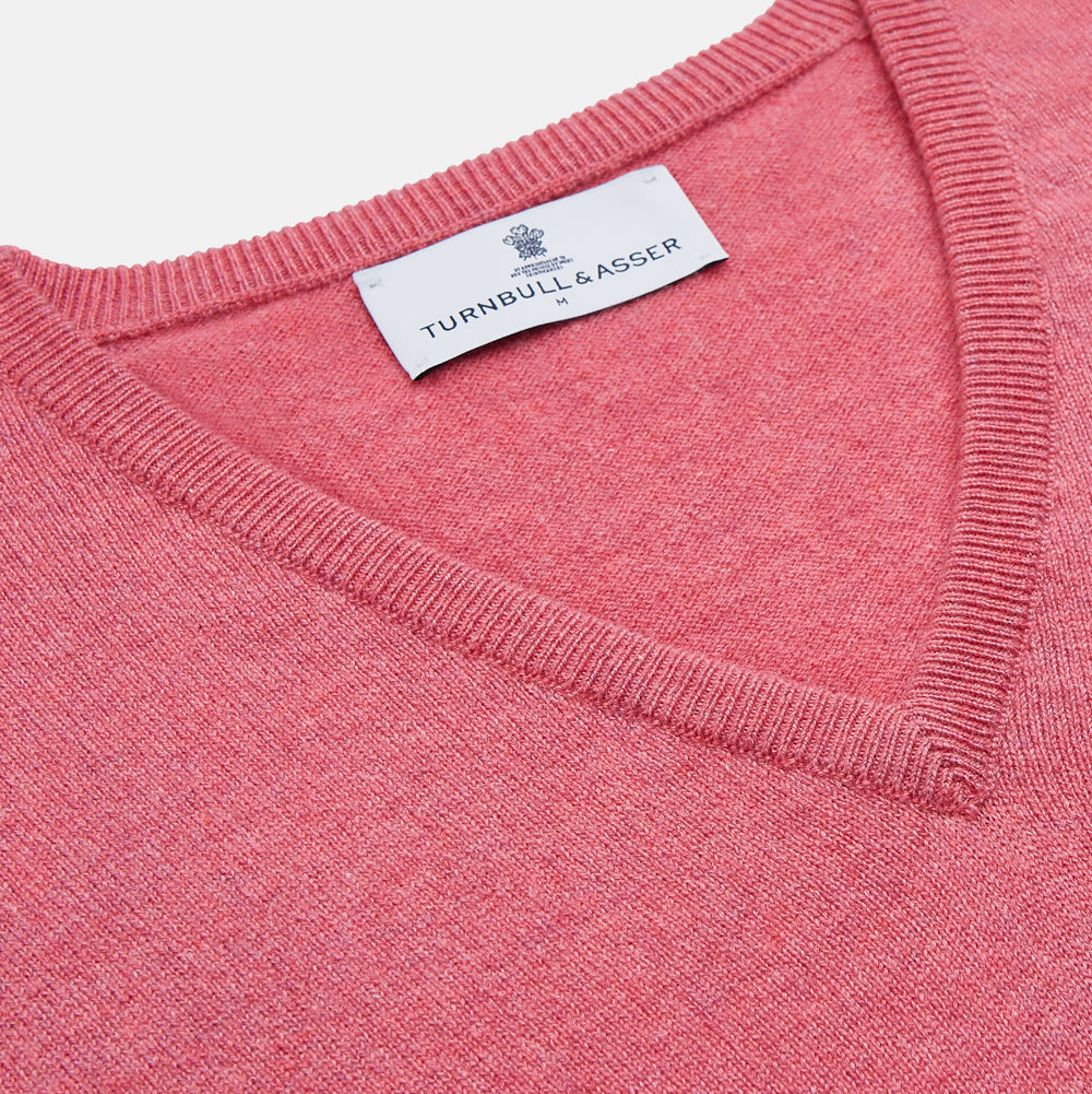 The Pink Cashmere Paden V-Neck Jumper by Turnbull & Asser, knitted in Scotland, is shown laid flat on a white background. This long-sleeved sweater features ribbed cuffs, hem, and neckline.