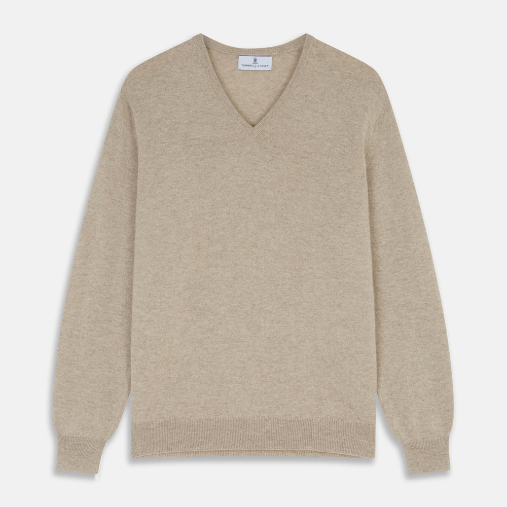 The Turnbull & Asser Beige Cashmere Paden V-Neck Jumper is laid flat on a white background. Knitted in Scotland, this men's staple features ribbed cuffs, hem, and neckline with a soft, smooth texture.
