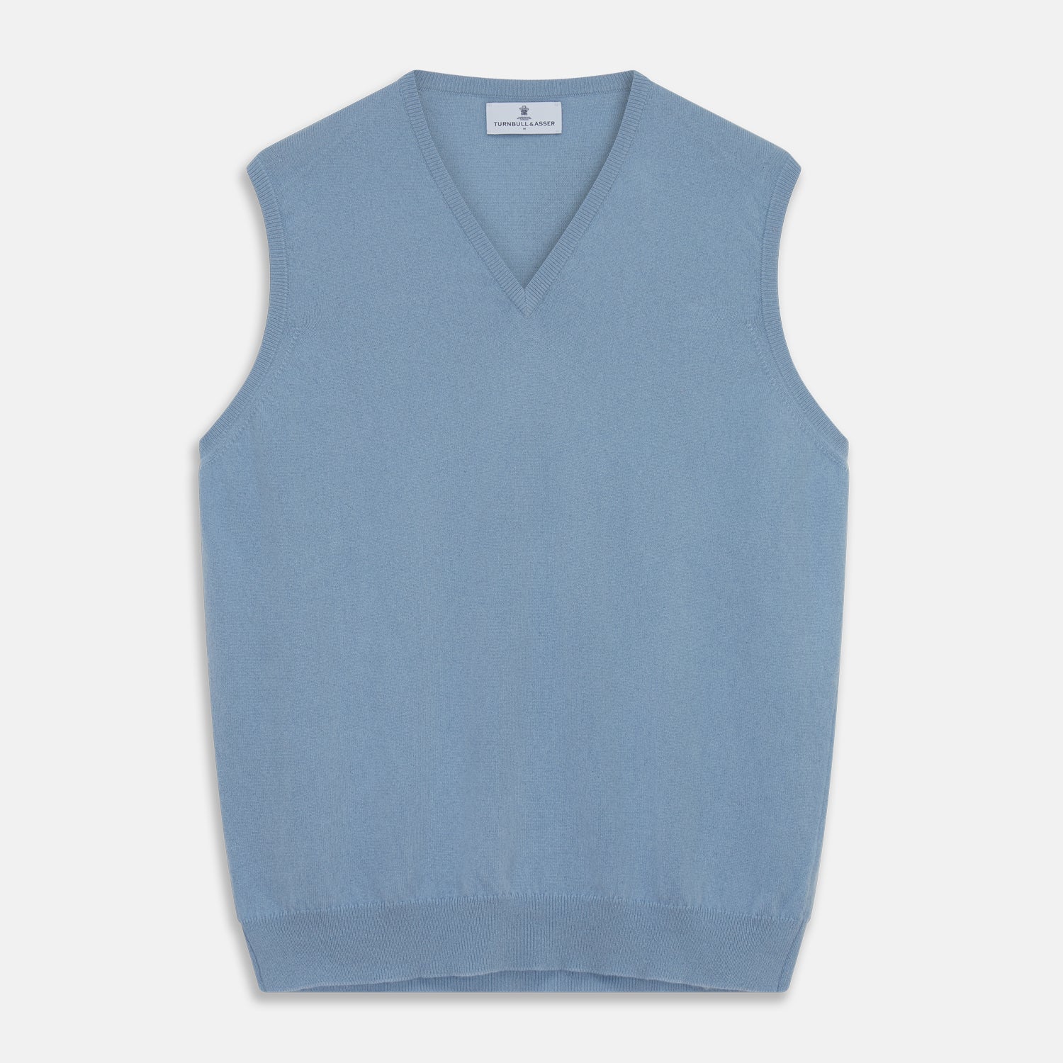 View 1 of product The Turnbull & Asser Pale Blue Cashmere Ifor Slipover is a sleeveless V-neck sweater vest with ribbed edges, shown laid flat on a white background—a classic menswear staple.