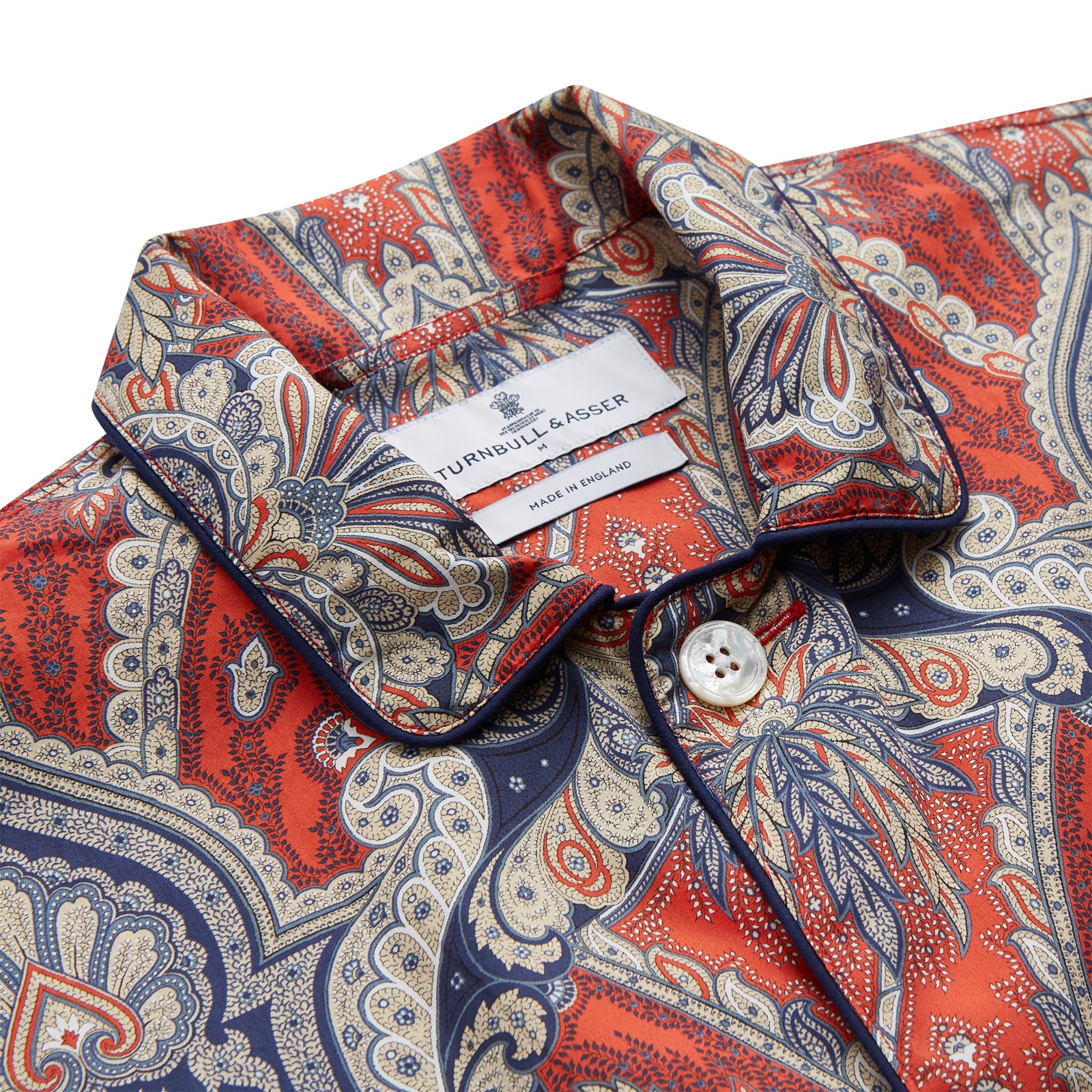 View 2 of product The Turnbull & Asser Red Baroque Silk-Blend Hyde Pyjama Set features a long-sleeve button-up shirt and matching pants in an intricate red, blue, and beige floral-geometric print, displayed flat against a white background.