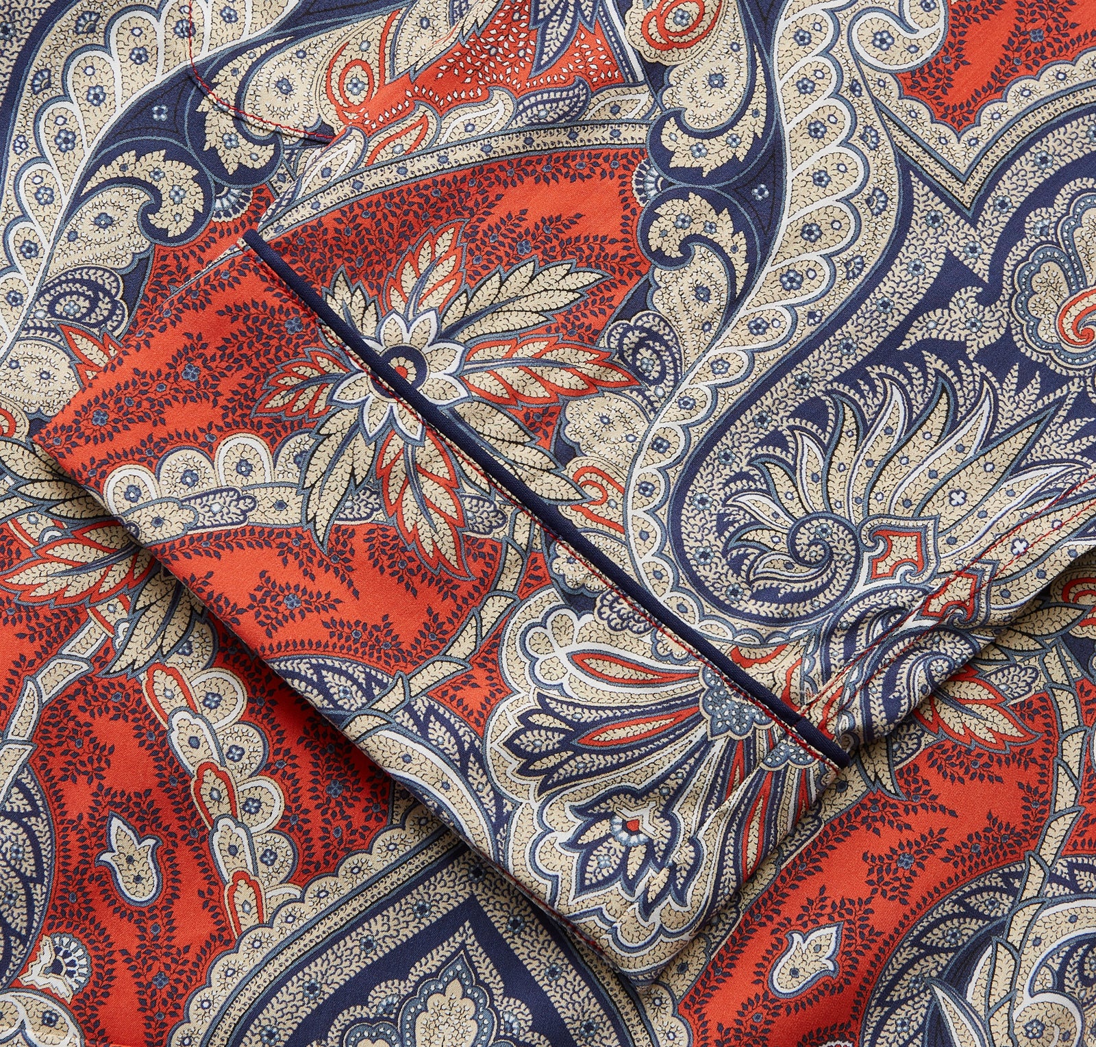 View 4 of product The Turnbull & Asser Red Baroque Silk-Blend Hyde Pyjama Set features a long-sleeve button-up shirt and matching pants in an intricate red, blue, and beige floral-geometric print, displayed flat against a white background.