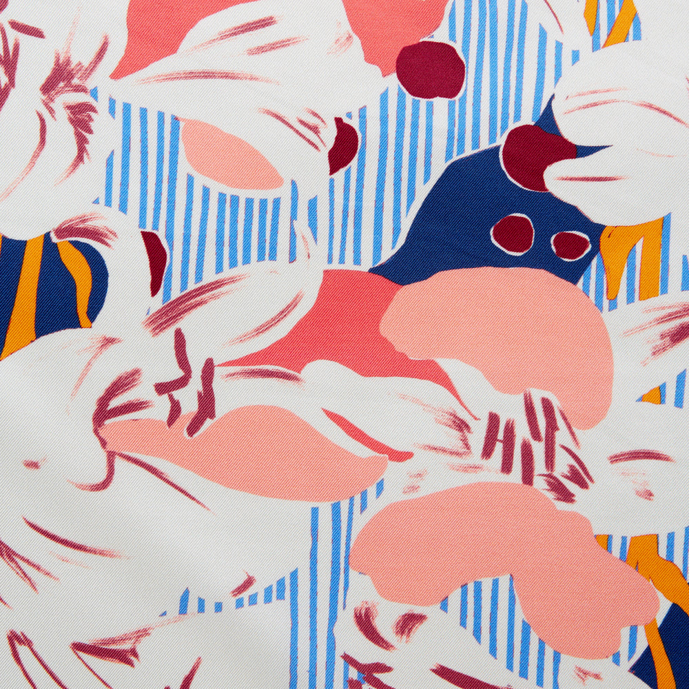 The Pink and Red Lily Silk Pocket Square by Turnbull & Asser features a vibrant, hand-drawn floral design with large lilies and abstract shapes in pink, white, blue, and yellow on pale blue vertical stripes.