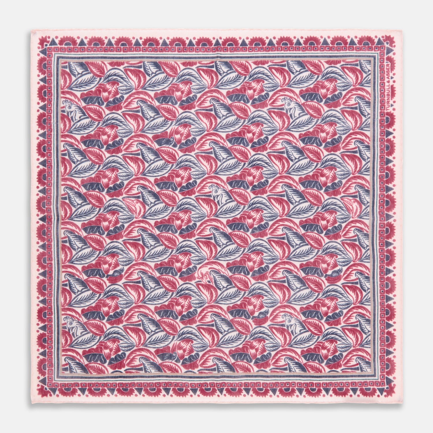 View 1 of product The Turnbull & Asser Pink And Blue Tropical Bird Pattern Wool Pocket Square is a lightweight accessory, featuring vibrant pink and blue birds on wool with a bold geometric border.