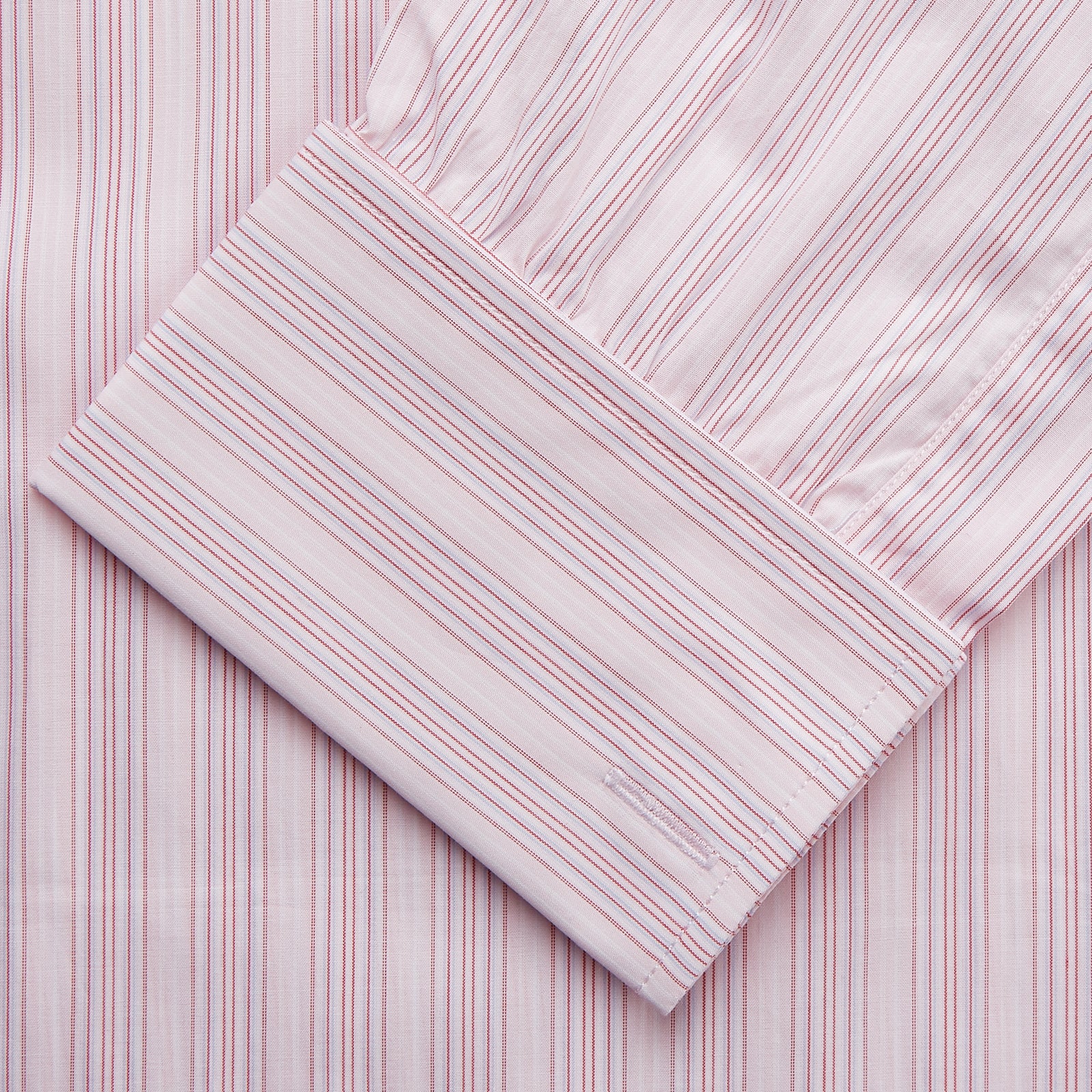 View 3 of product The Pink and Peach Multi Stripe Cotton Regular Fit Whitby Shirt by Turnbull & Asser features long sleeves, double cuffs, a button-down front, and a classic collar; shown laid flat on a white background.