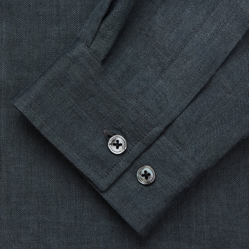 The Turnbull & Asser Grey Cotton and Linen Blend Holiday Fit Winnington Shirt features long sleeves, a spread collar, a left chest pocket, and white buttons, shown against a plain white background.