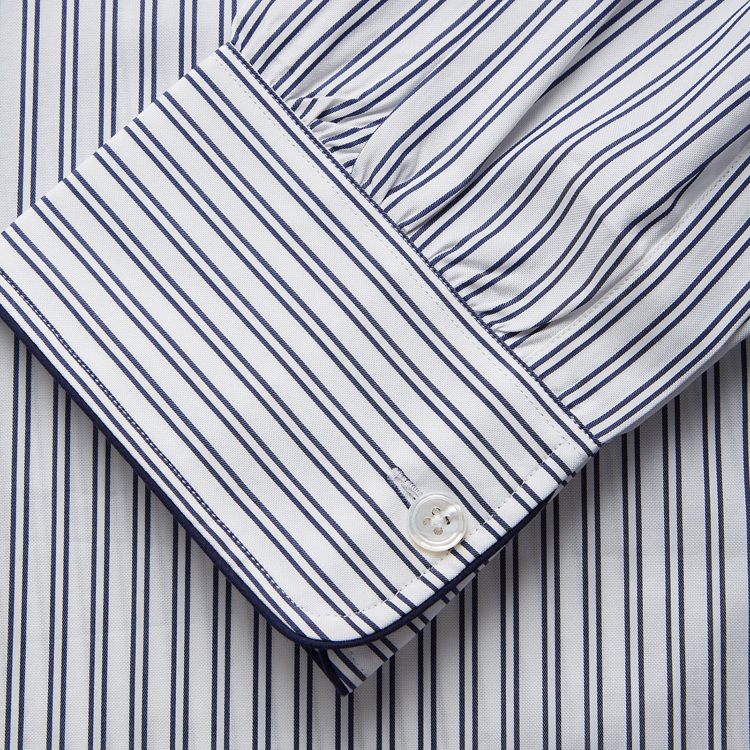 View 3 of product The Turnbull & Asser White and Navy Striped Cotton Sussex Nightshirt features long sleeves, a knee-length cut, a collar, front buttons, a chest pocket with dark trim, and a curved hem for modern comfort inspired by tradition.