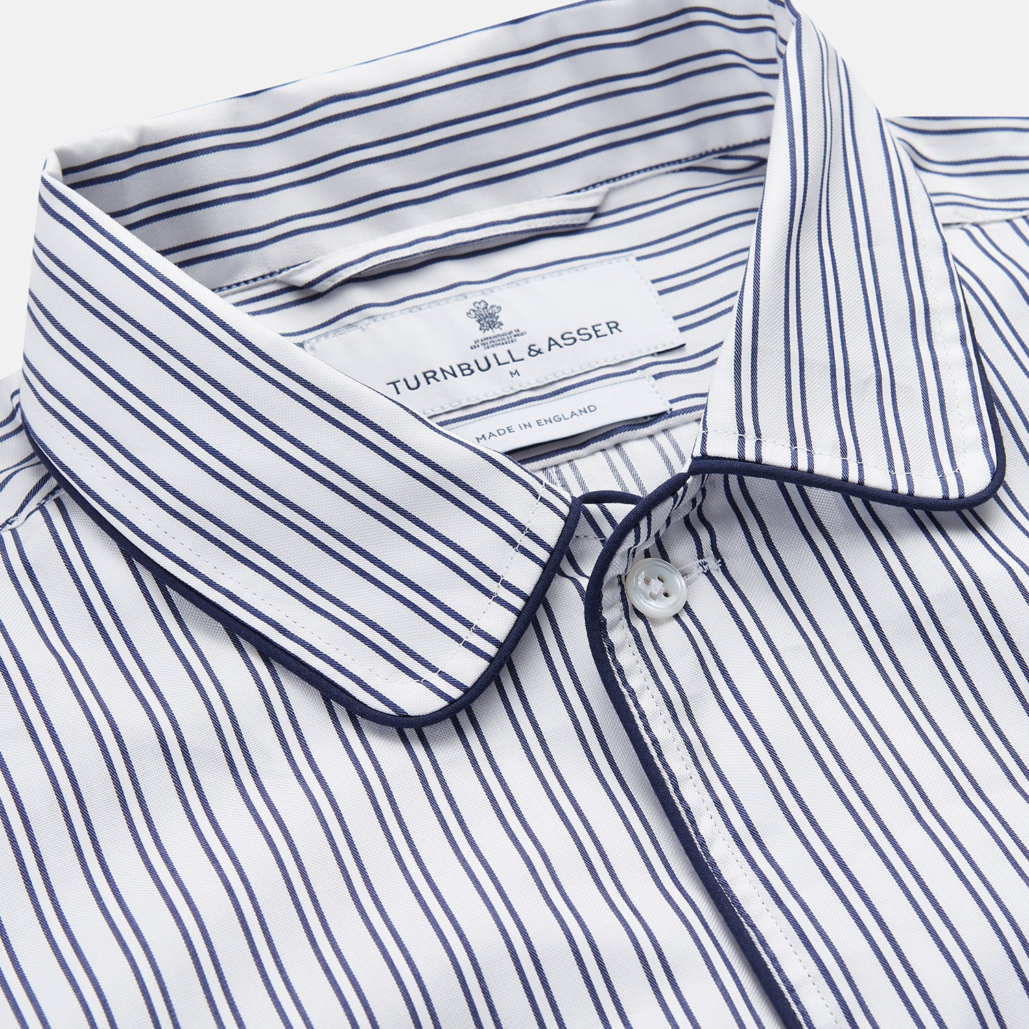 View 2 of product The Turnbull & Asser White and Navy Striped Cotton Sussex Nightshirt features long sleeves, a knee-length cut, a collar, front buttons, a chest pocket with dark trim, and a curved hem for modern comfort inspired by tradition.