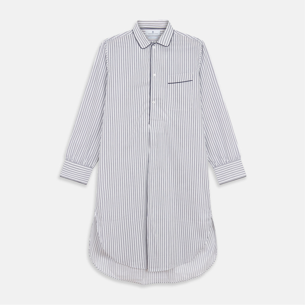 The Turnbull & Asser White and Navy Striped Cotton Sussex Nightshirt features long sleeves, a knee-length cut, a collar, front buttons, a chest pocket with dark trim, and a curved hem for modern comfort inspired by tradition.