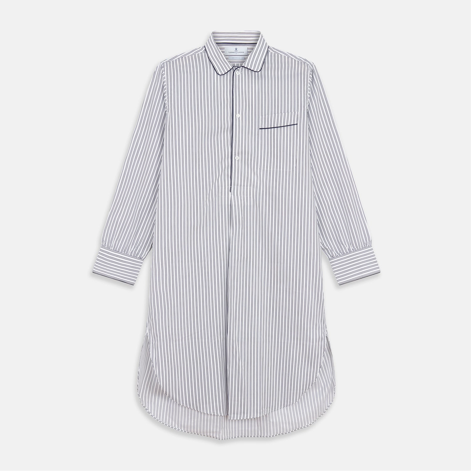 View 1 of product The Turnbull & Asser White and Navy Striped Cotton Sussex Nightshirt features long sleeves, a knee-length cut, a collar, front buttons, a chest pocket with dark trim, and a curved hem for modern comfort inspired by tradition.