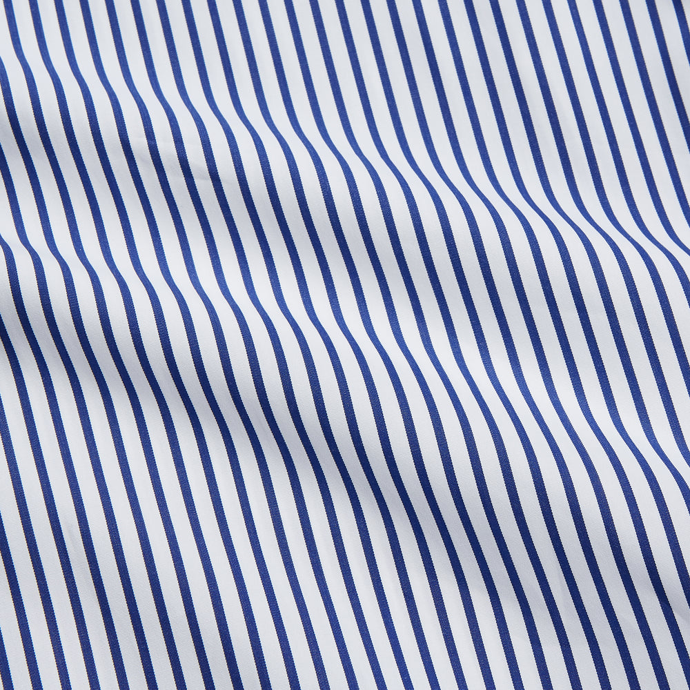 The Turnbull & Asser Navy Stripe Cotton Regular Fit Whitby Shirt features vertical blue and white stripes, long sleeves, a collar, double cuffs, and a button-down front, shown laid flat on a white background.