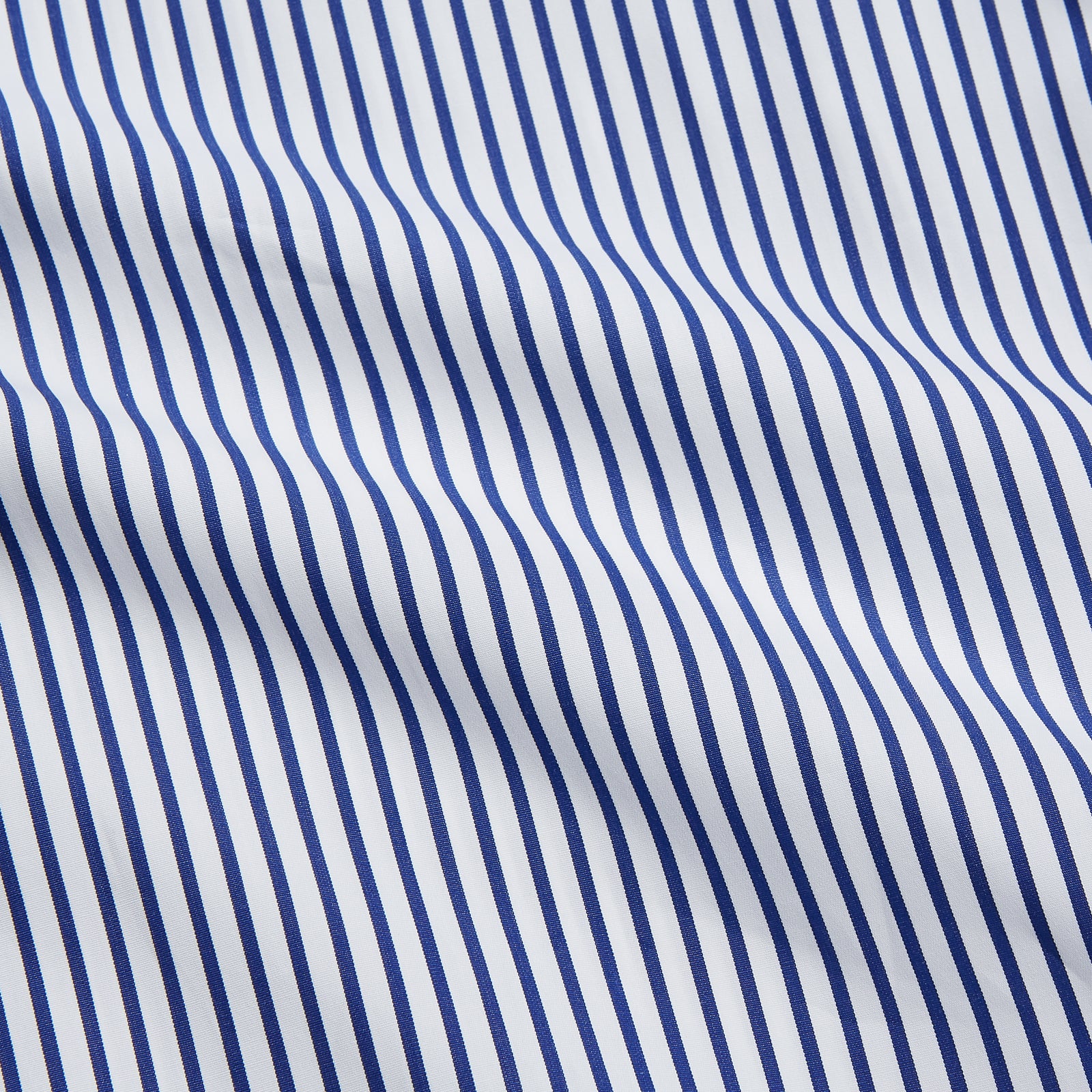 View 4 of product The Turnbull & Asser Navy Stripe Cotton Regular Fit Whitby Shirt features vertical blue and white stripes, long sleeves, a collar, double cuffs, and a button-down front, shown laid flat on a white background.