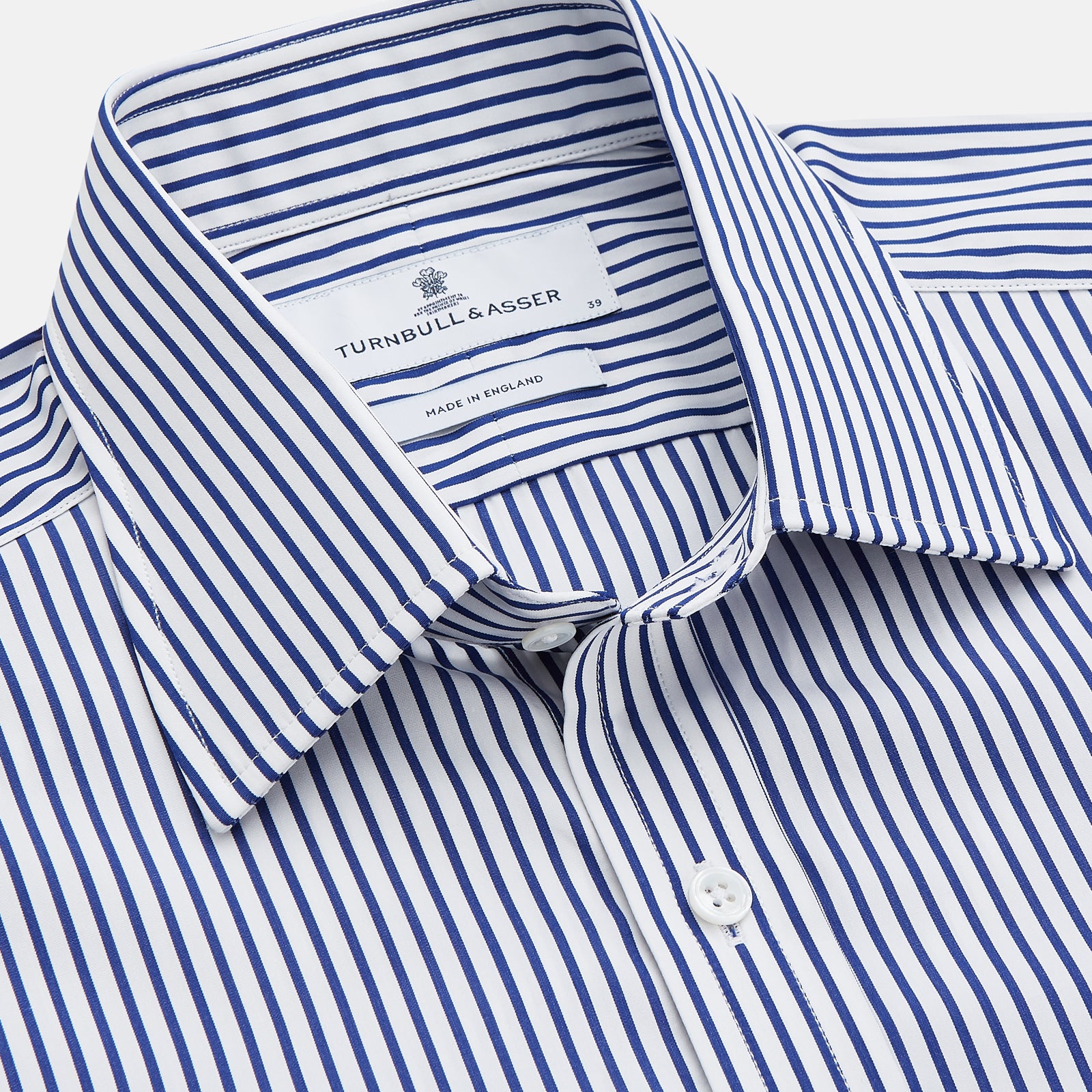 View 2 of product The Turnbull & Asser Navy Stripe Cotton Regular Fit Whitby Shirt features vertical blue and white stripes, long sleeves, a collar, double cuffs, and a button-down front, shown laid flat on a white background.