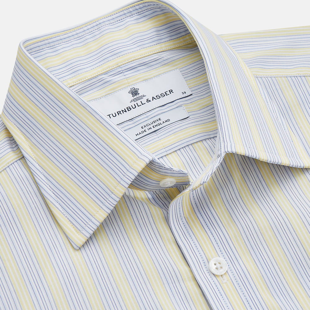 The Yellow and Pale Blue Multi Stripe Cotton Regular Fit Whitby Shirt by Turnbull & Asser features light blue and yellow stripes on white, a classic collar, white buttons, long sleeves, and wide double cuffs.