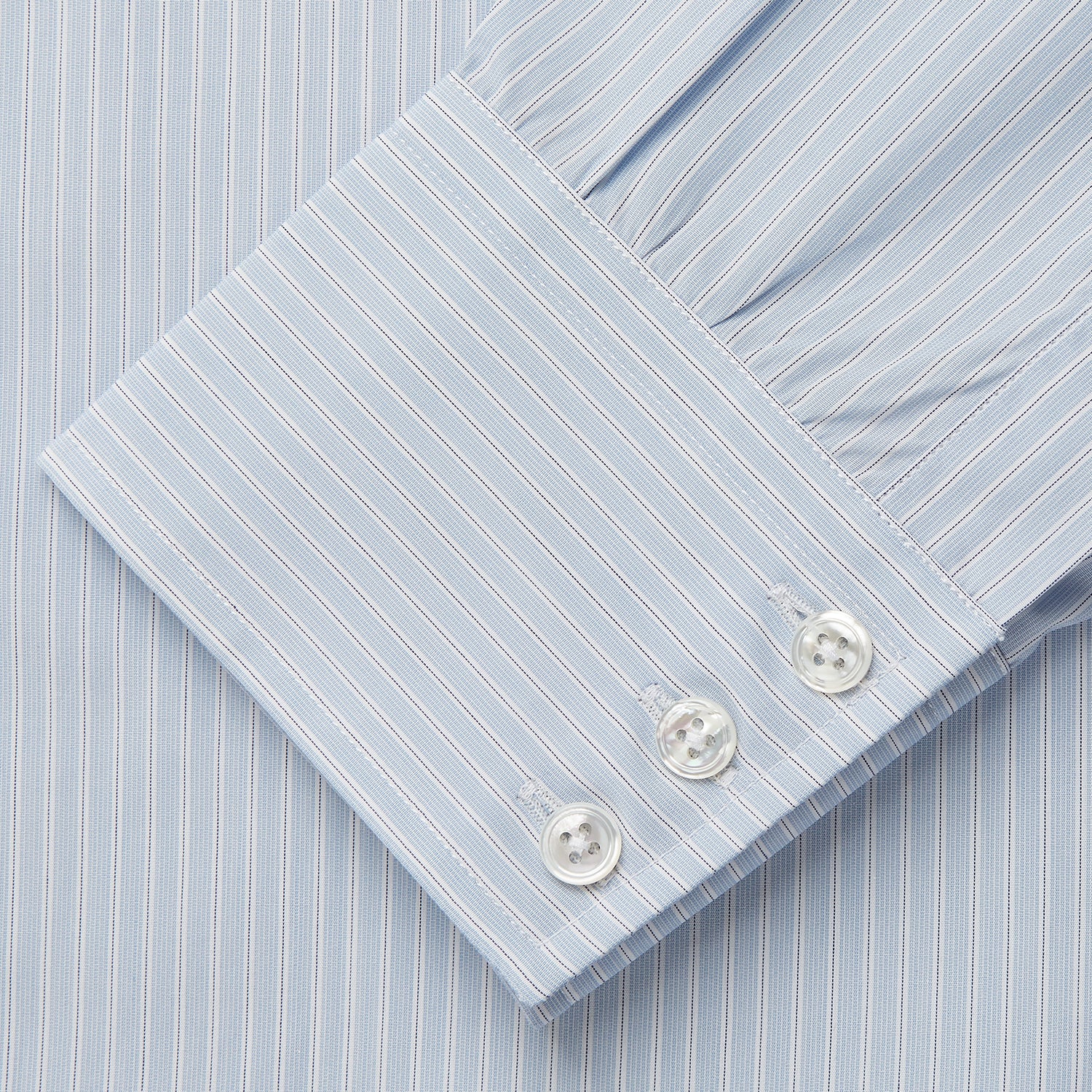 View 4 of product The Turnbull & Asser Pale Blue Stripe West Indian Sea Island Cotton Regular Fit Mayfair Shirt features long sleeves, a button-down front, and a classic collar—an essential for any men's wardrobe, shown on a plain white background.