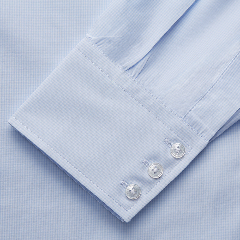 The Light Blue Multi-Check Cotton Regular Fit Mayfair Shirt by Turnbull & Asser is shown laid flat, featuring a classic T&A collar, front buttons, and buttoned cuffs on a white background.