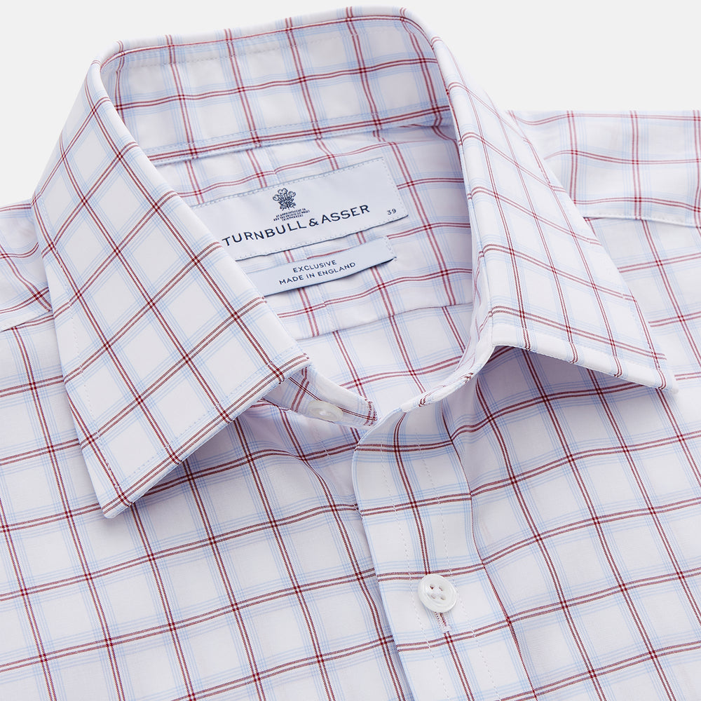 The Turnbull & Asser Red and Blue Multi-check Cotton Regular Fit Mayfair Shirt features a white base with red and blue checks, long sleeves, a T&A collar, and is shown flat against a white surface.