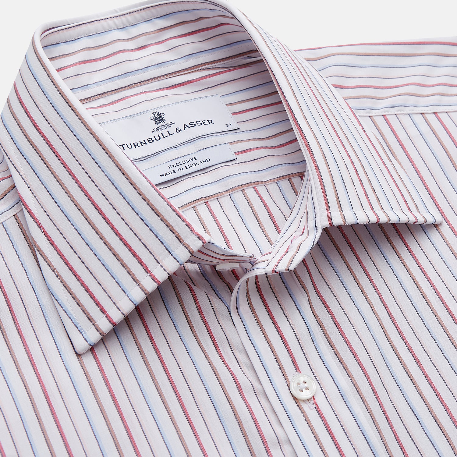 View 2 of product The Turnbull & Asser Red Multi-stripe Cotton Regular Fit Mayfair Shirt features red and blue vertical stripes on white, a T&A collar, and long sleeves. The shirt is shown neatly laid flat on a white surface.