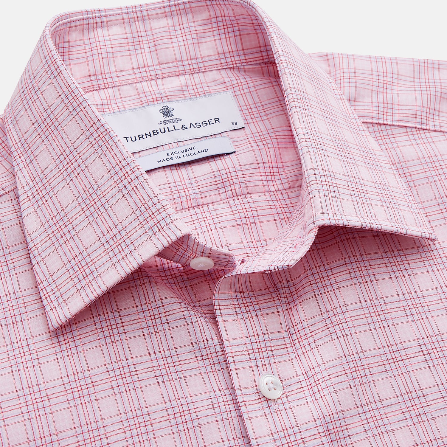 View 2 of product The Turnbull & Asser Pink Multi-check Cotton Regular Fit Mayfair Shirt features long sleeves, a T&A collar, buttoned cuffs, and a light pink check pattern, shown against a plain white background.