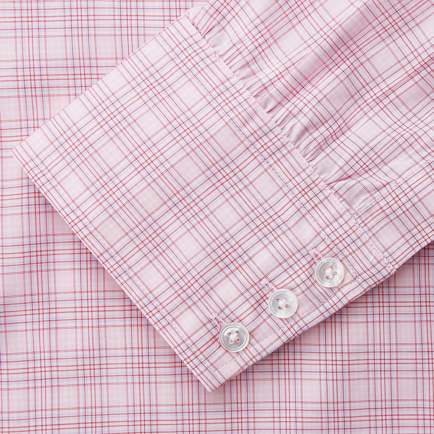 View 3 of product The Turnbull & Asser Pink Multi-check Cotton Regular Fit Mayfair Shirt features long sleeves, a T&A collar, buttoned cuffs, and a light pink check pattern, shown against a plain white background.