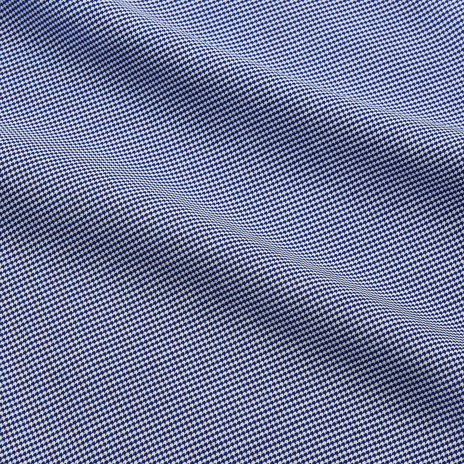 View 4 of product The Turnbull & Asser Navy Pattern Cotton Voile Tailored Fit Shelton Shirt is laid flat, showcasing its classic collar and white front and cuff buttons.