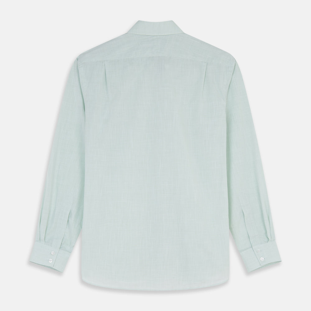 The Turnbull & Asser Light Green Chambray Tailored Fit Shelton Shirt features long sleeves, a classic collar, and white buttons—an elegant men's formal shirt shown neatly laid flat on a white background.