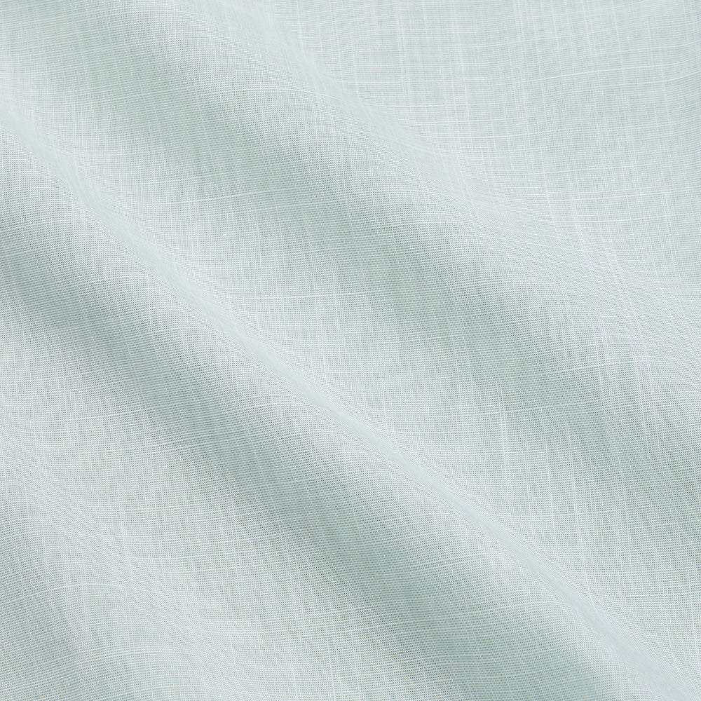 The Turnbull & Asser Light Green Chambray Tailored Fit Shelton Shirt features long sleeves, a classic collar, and white buttons—an elegant men's formal shirt shown neatly laid flat on a white background.
