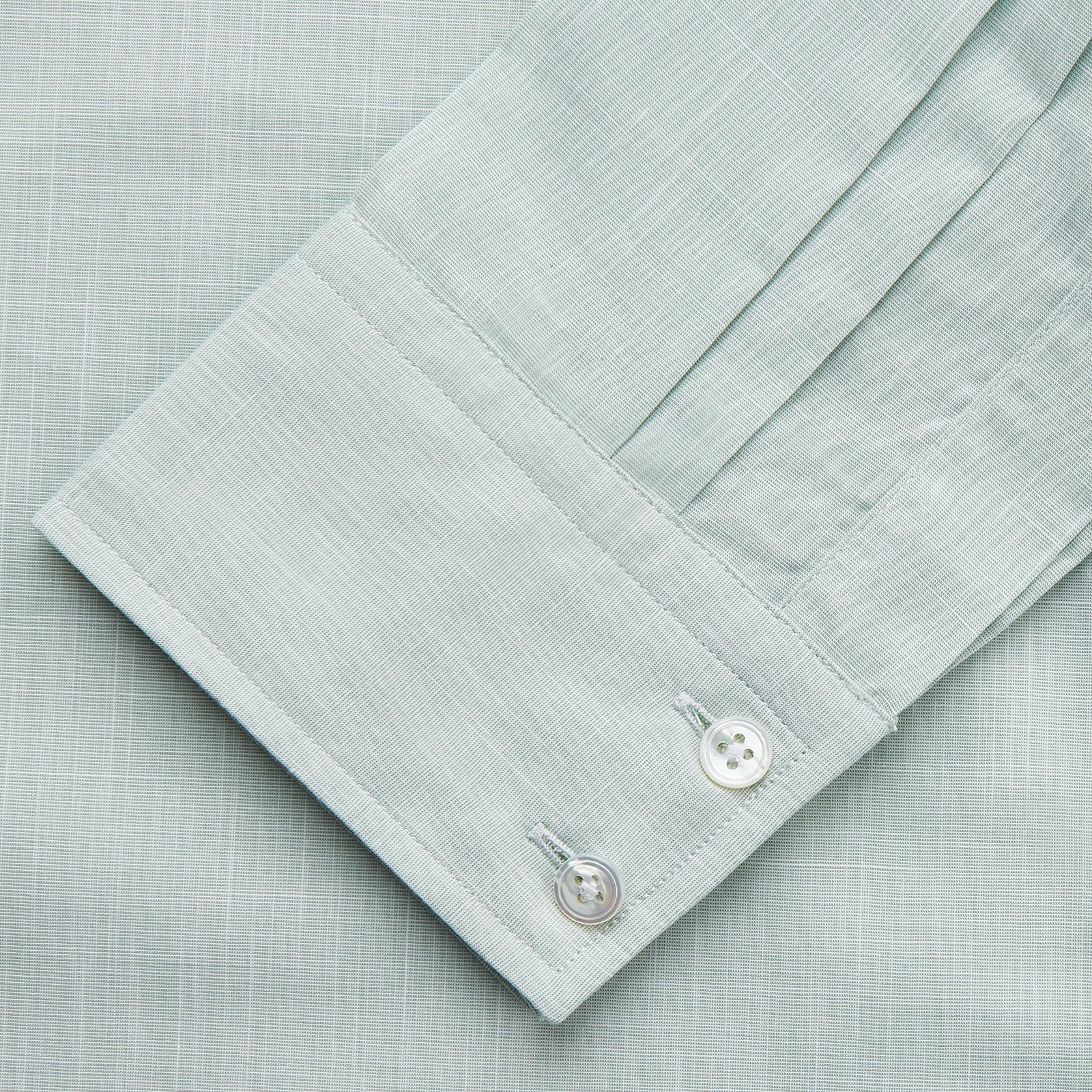 View 3 of product The Turnbull & Asser Light Green Chambray Tailored Fit Shelton Shirt features long sleeves, a classic collar, and white buttons—an elegant men's formal shirt shown neatly laid flat on a white background.