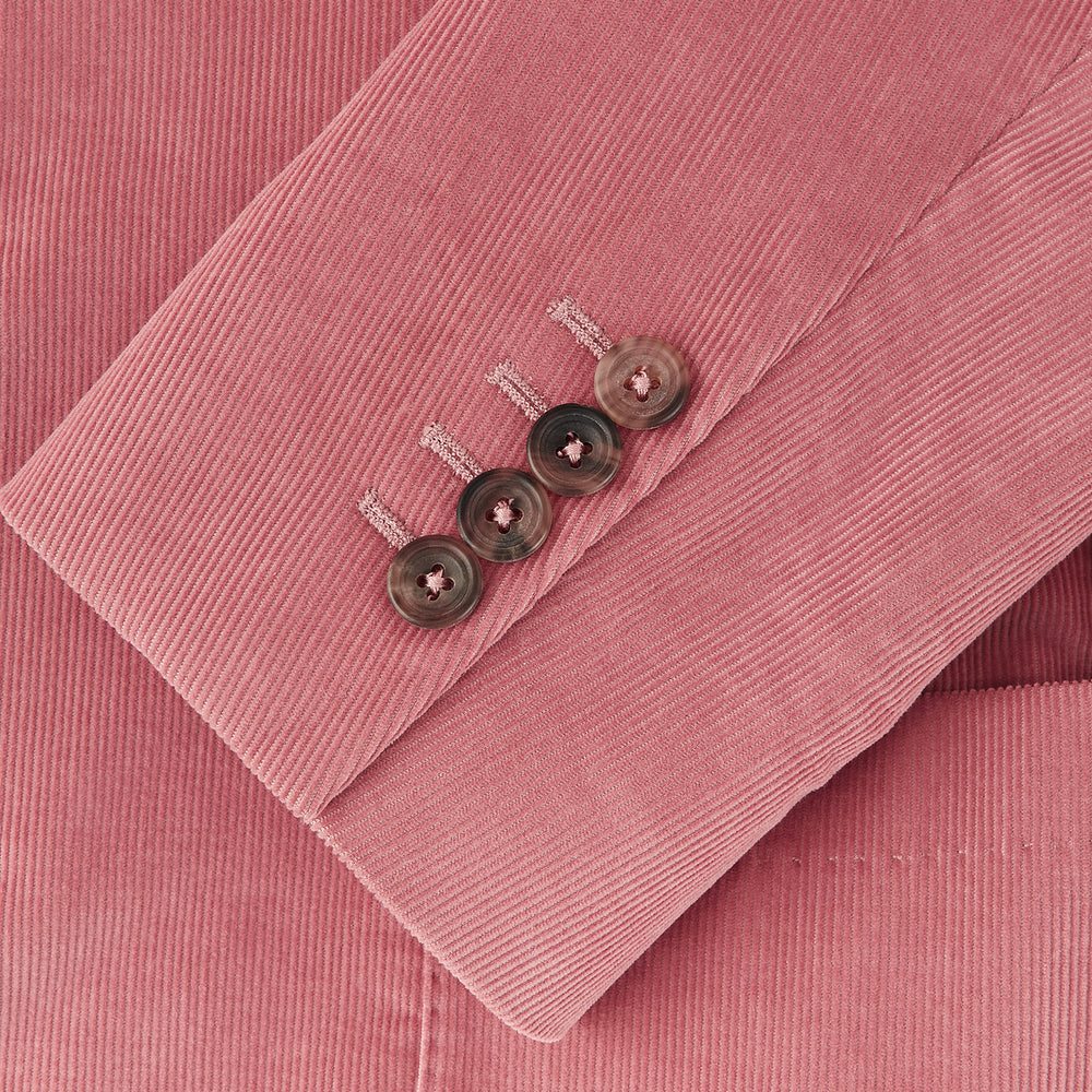 The Turnbull & Asser Pink Cord Bern Blazer features notch lapels, two brown buttons, three front pockets, and buttoned cuffs, showcasing Italian tailoring against a plain white background.