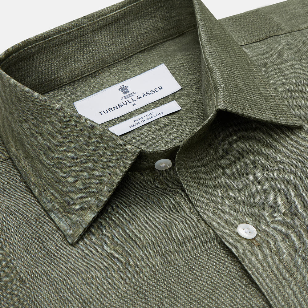 The Sage Green Linen Weekend Fit Finch Shirt by Turnbull & Asser features a classic collar, white buttons, and a single chest pocket—an essential piece for any men's wardrobe. Displayed flat on a white background for a clean look.