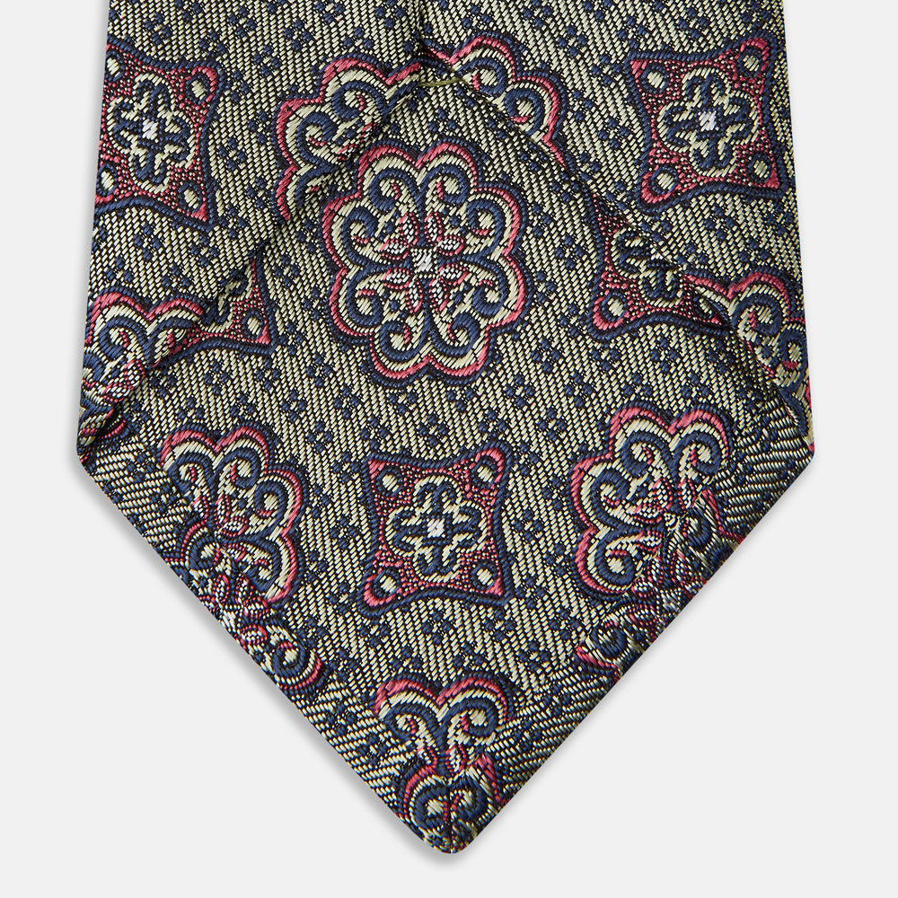 The Green Floral Tile Silk Tie by Turnbull & Asser features a gold background with a repeating green floral pattern in red, navy blue, and cream, showcasing classic style and an evenly distributed silk texture throughout.