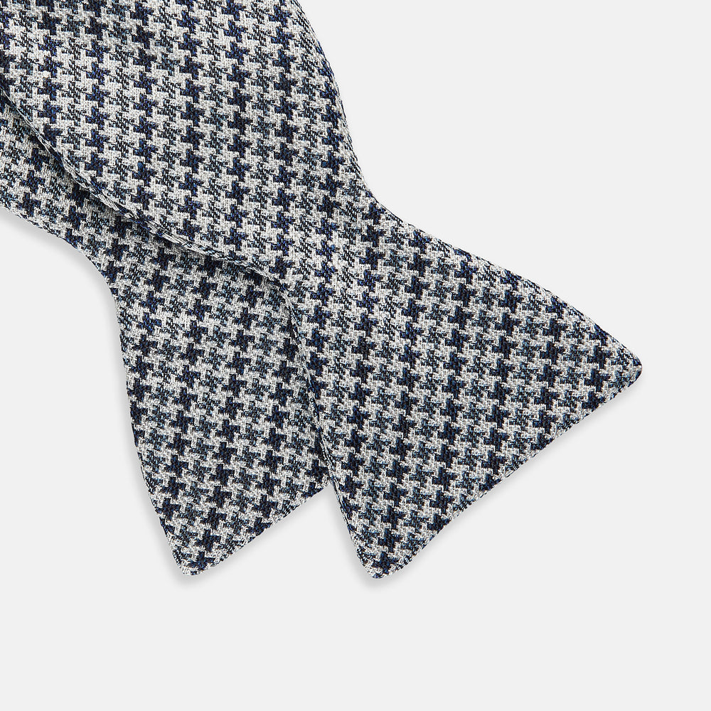 The Turnbull & Asser Blue Multi Puppytooth Silk Bow Tie features a classic puppytooth pattern in shades of blue, displayed against a plain white background.