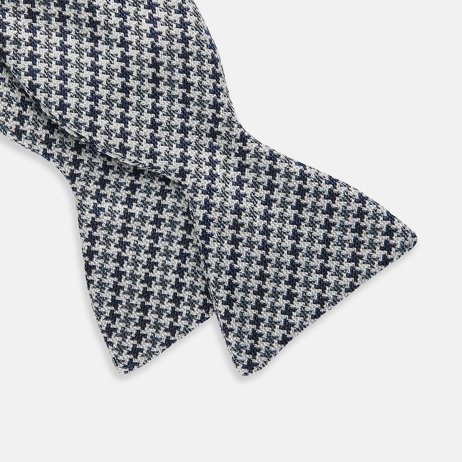 View 3 of product The Turnbull & Asser Blue Multi Puppytooth Silk Bow Tie features a classic puppytooth pattern in shades of blue, displayed against a plain white background.