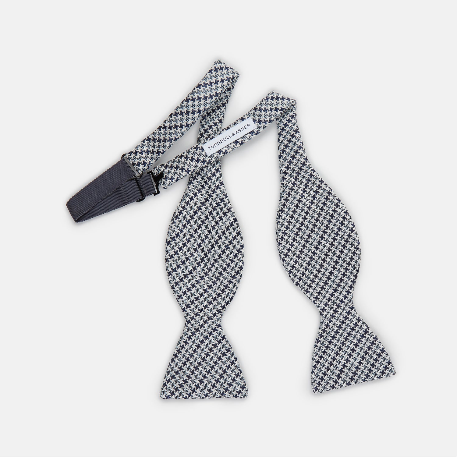 View 2 of product The Turnbull & Asser Blue Multi Puppytooth Silk Bow Tie features a classic puppytooth pattern in shades of blue, displayed against a plain white background.