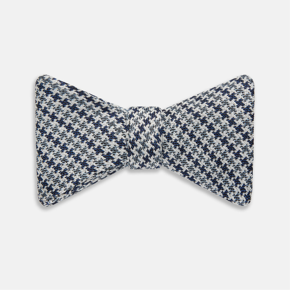 The Turnbull & Asser Blue Multi Puppytooth Silk Bow Tie features a classic puppytooth pattern in shades of blue, displayed against a plain white background.