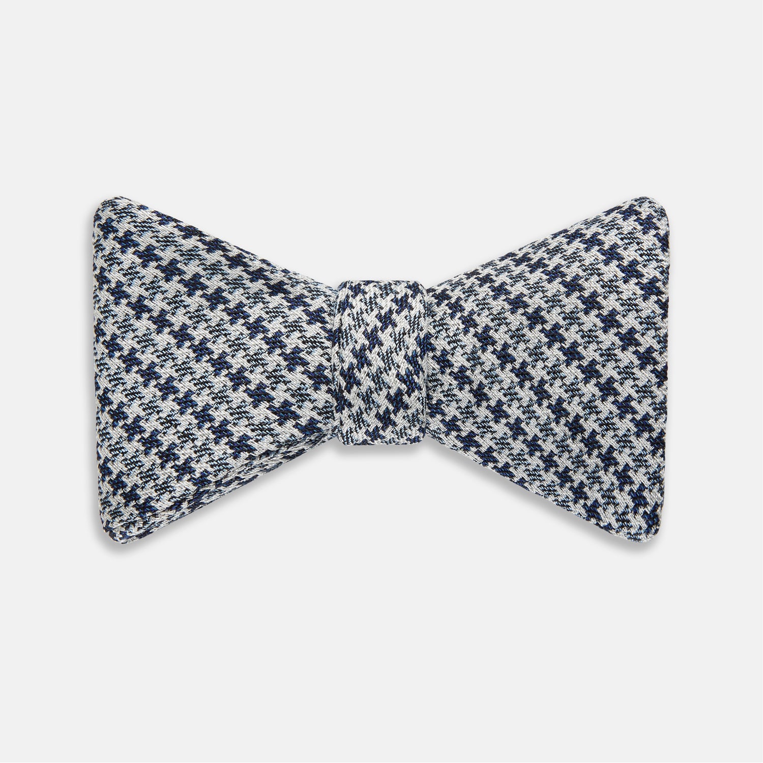 View 1 of product The Turnbull & Asser Blue Multi Puppytooth Silk Bow Tie features a classic puppytooth pattern in shades of blue, displayed against a plain white background.
