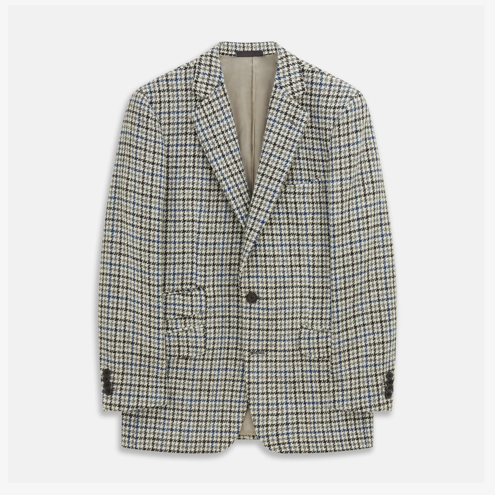 The Grey and Navy Tweed Barrington Blazer by Turnbull & Asser is a single-breasted jacket with notched lapels, two front buttons, flap pockets, and a tailored fit—expertly made in Italy for sophisticated style.
