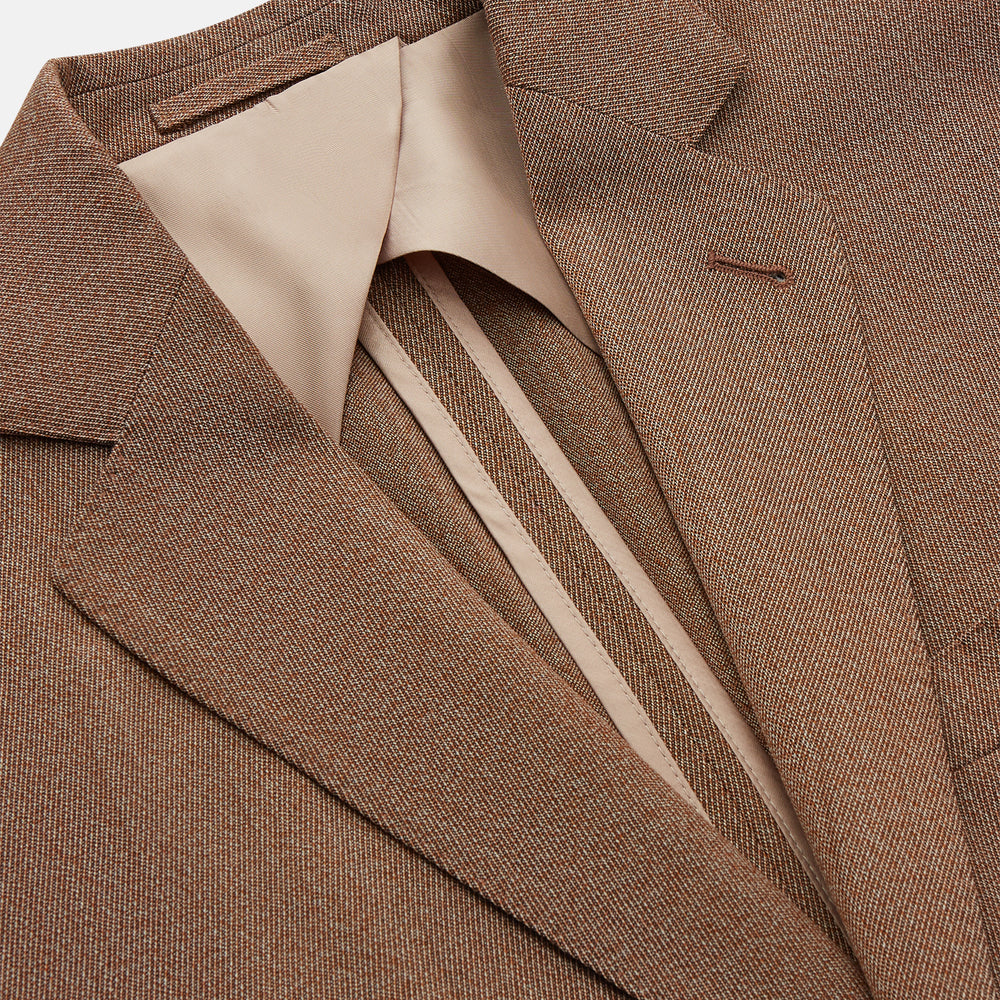 The Brown Virgin Wool Bern Blazer by Turnbull & Asser features notch lapels, two front patch pockets, a chest pocket, buttoned cuffs, and two buttons, shown over a beige collared shirt against a white background.