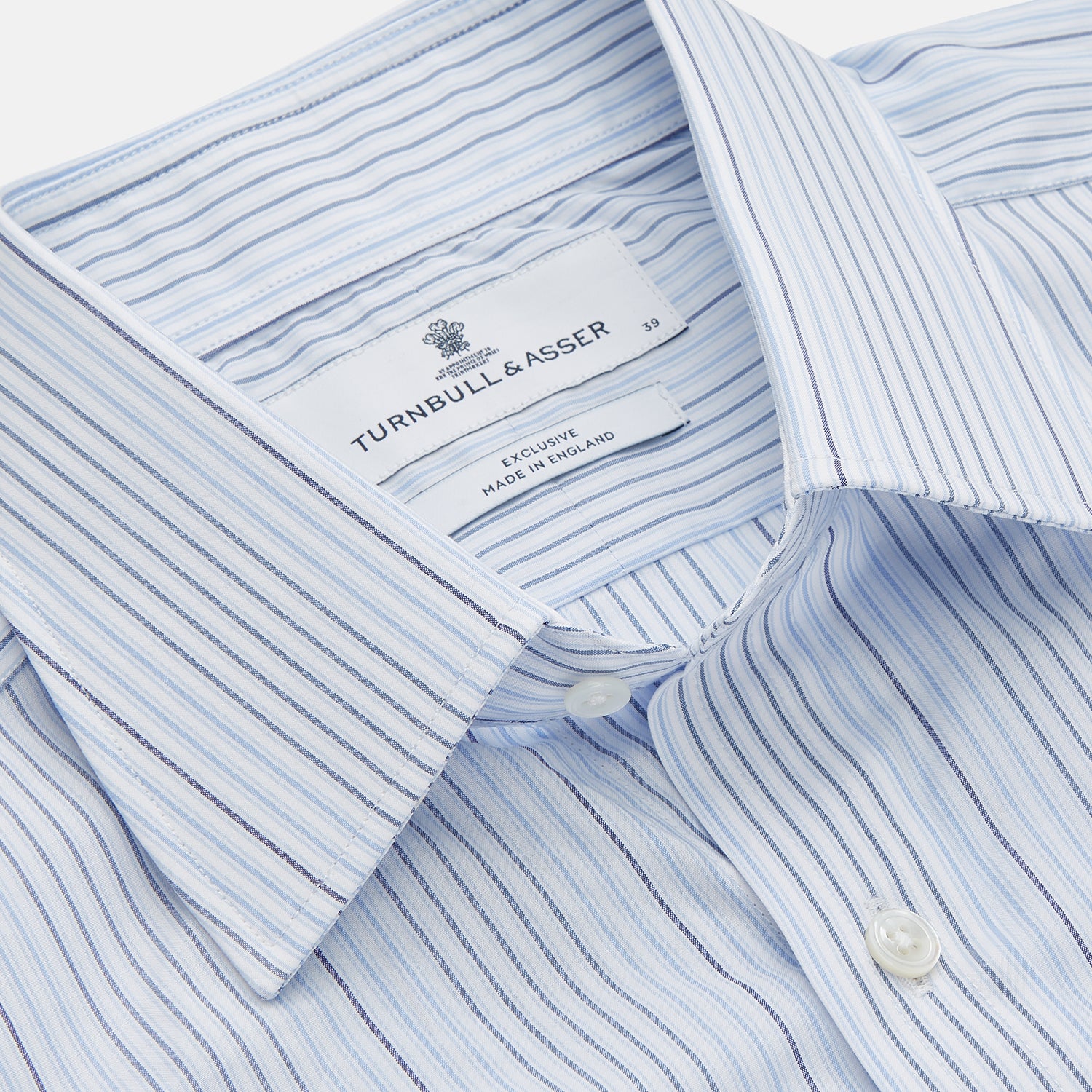 View 2 of product Turnbull & Asser’s Blue and White Stripe Twill Cotton Regular Fit Shirt features a T&A collar, double cuffs, and classic stripes, shown laid flat on a white background.
