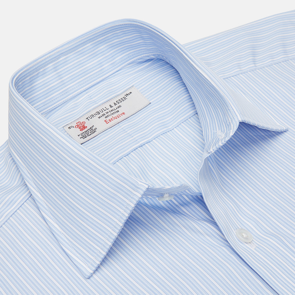 The Turnbull & Asser Light Blue Rich Stripe Shirt features a T&A collar, three-button cuffs, and fine white vertical stripes. Shown neatly laid flat on a white background.