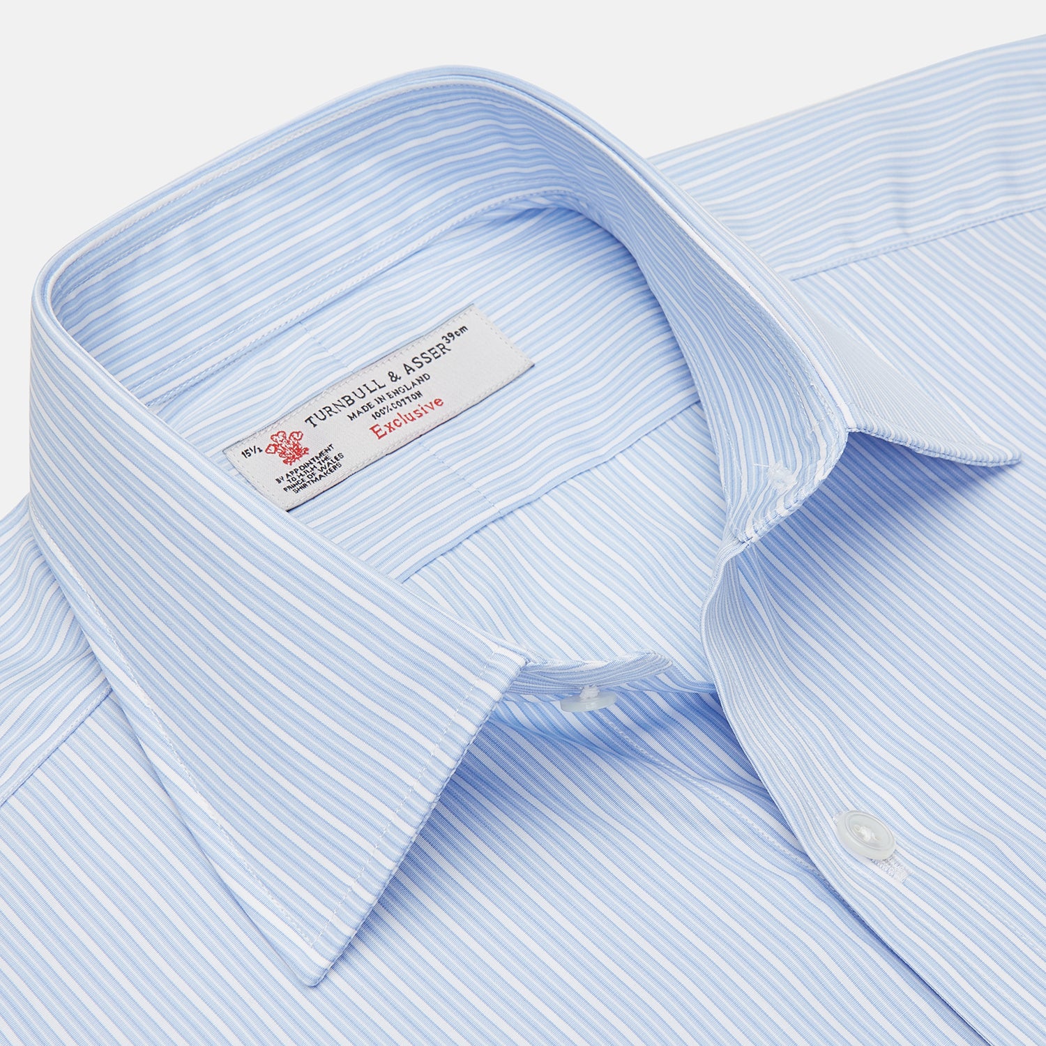 View 3 of product The Turnbull & Asser Light Blue Rich Stripe Shirt features a T&A collar, three-button cuffs, and fine white vertical stripes. Shown neatly laid flat on a white background.