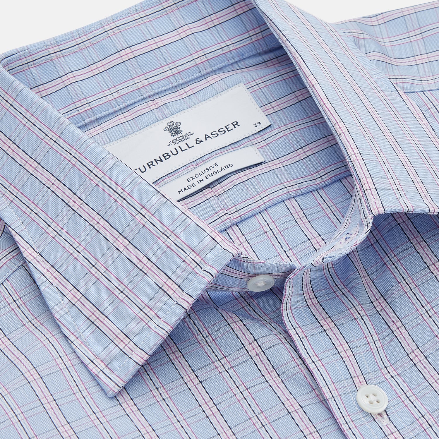 View 2 of product The Turnbull & Asser Blue and Pink Check Poplin Cotton Regular Fit Shirt features a T&A collar, 3-button cuffs, and a blue and pink check pattern, shown laid flat on a white background.