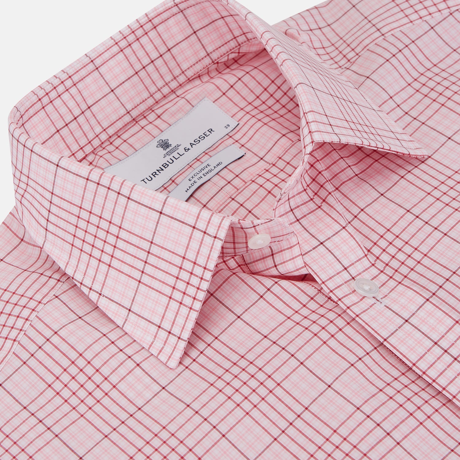 View 2 of product The Turnbull & Asser Pink Fine Check Shirt features superfine cotton Zephir, a T&A collar, and three-button cuffs, shown laid flat on a white background.