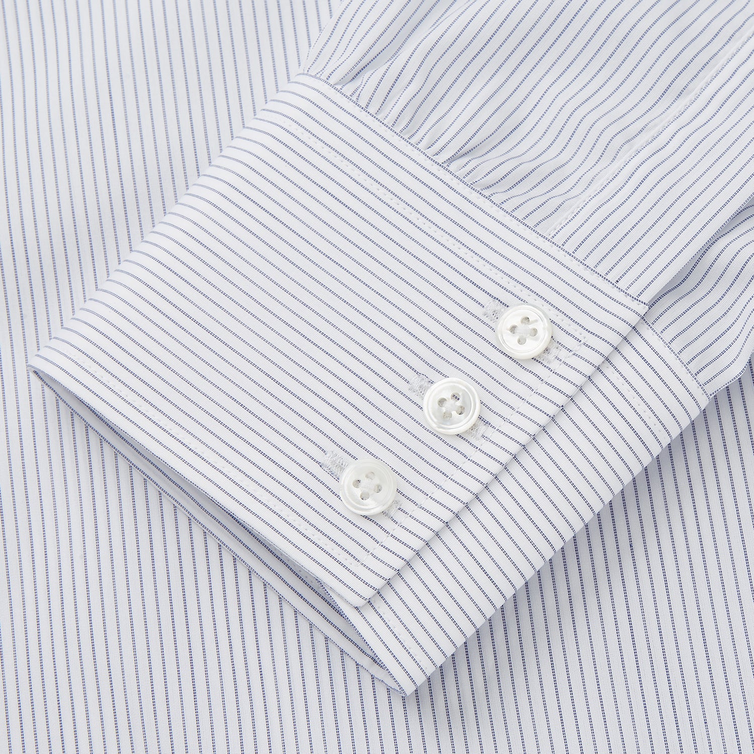 View 3 of product The Turnbull & Asser White and Blue Stripe Sea Island Quality Cotton Shirt features a T&A collar, 3-button cuffs, and fine vertical stripes, displayed on a white background.