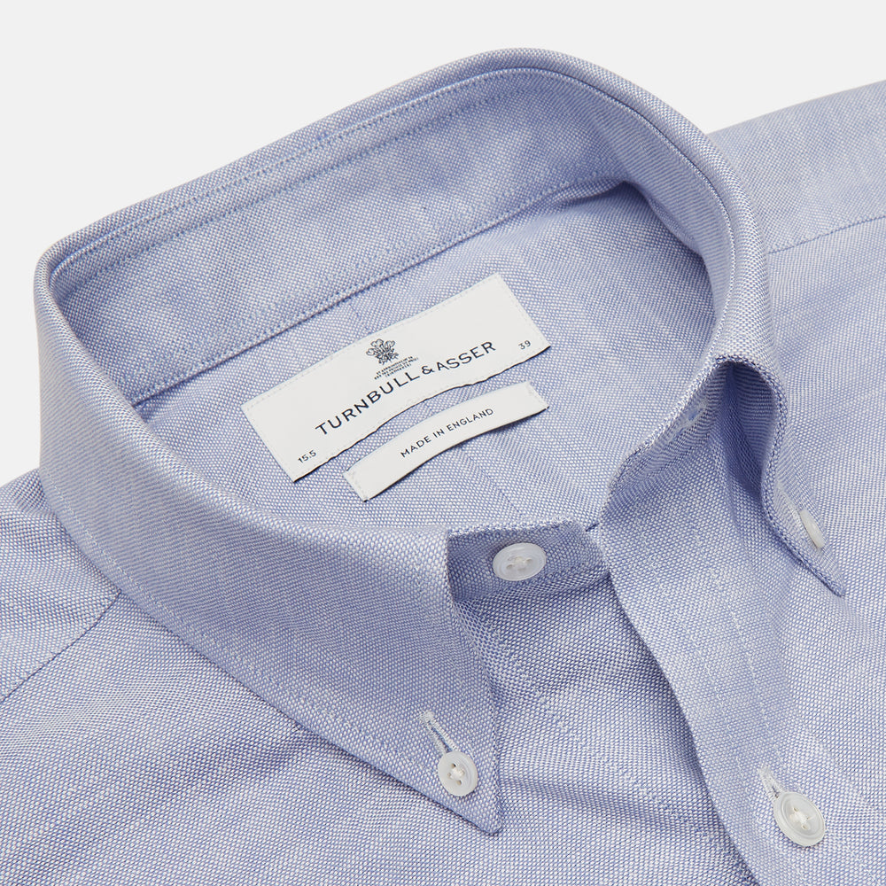 The Turnbull & Asser Blue Chambray Weekend Fit Shirt features a Dorset collar, 1-button cuffs, and white buttons, shown flat on a white background.