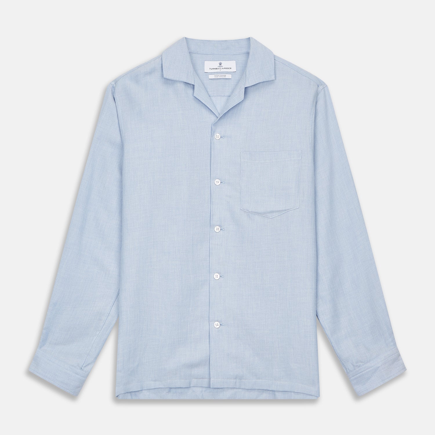 View 1 of product The Turnbull & Asser Holiday Fit Blue Cotton and Cashmere Blend Shirt features long sleeves, a classic collar, single chest pocket, and 1-button cuffs with white buttons, shown laid flat on a white background.