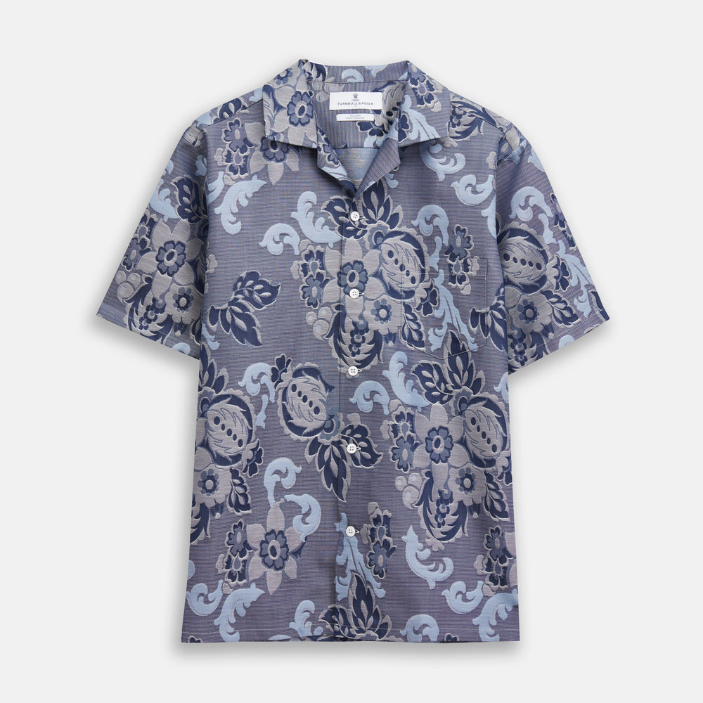 The Blue & White Tapestry Weave Cotton Holiday Fit Shirt by Turnbull & Asser features short sleeves, a revere collar, and a button-up front with a blue and white patterned textured fabric, shown against a plain white background.