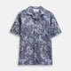 The Blue & White Tapestry Weave Cotton Holiday Fit Shirt by Turnbull & Asser features short sleeves, a revere collar, and a button-up front with a blue and white patterned textured fabric, shown against a plain white background.